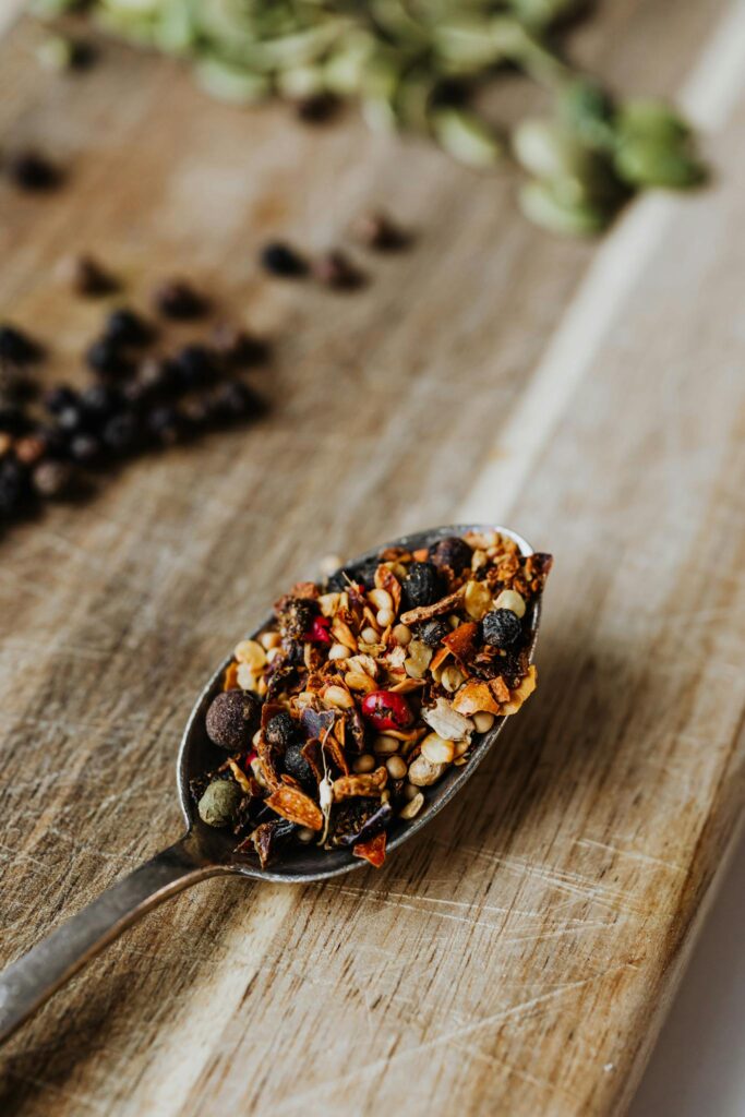 A detailed close-up of assorted spices on a rustic wooden spoon, perfect for culinary themes.